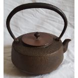 An antique Oriental iron teapot with alloy lid, signature to side