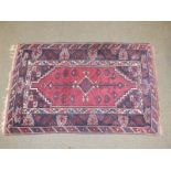 An early 20thC Oriental rug of geometric design with stepped red central medallion, 47" x 73" -