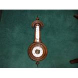 A Victorian walnut barometer, 23" high overall.