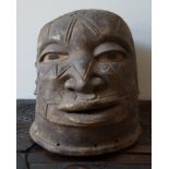 An African Makonde helmet mask, the carved face with expression and remnants of inlaid hair.