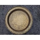 An embossed brass dish decorated with stylised flowerheads, 17.5" diameter.