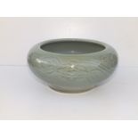 A Chinese celadon glazed porcelain bowl, the thickly potted body with in-curved rim, the sides