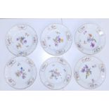 A set of six late 19thC Meissen porcelain plates painted polychrome floral sprays within gilt rococo