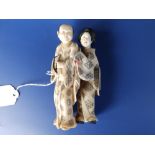 A Japanese Meiji period ivory okimono carving depicting a man with a staff holding a string of