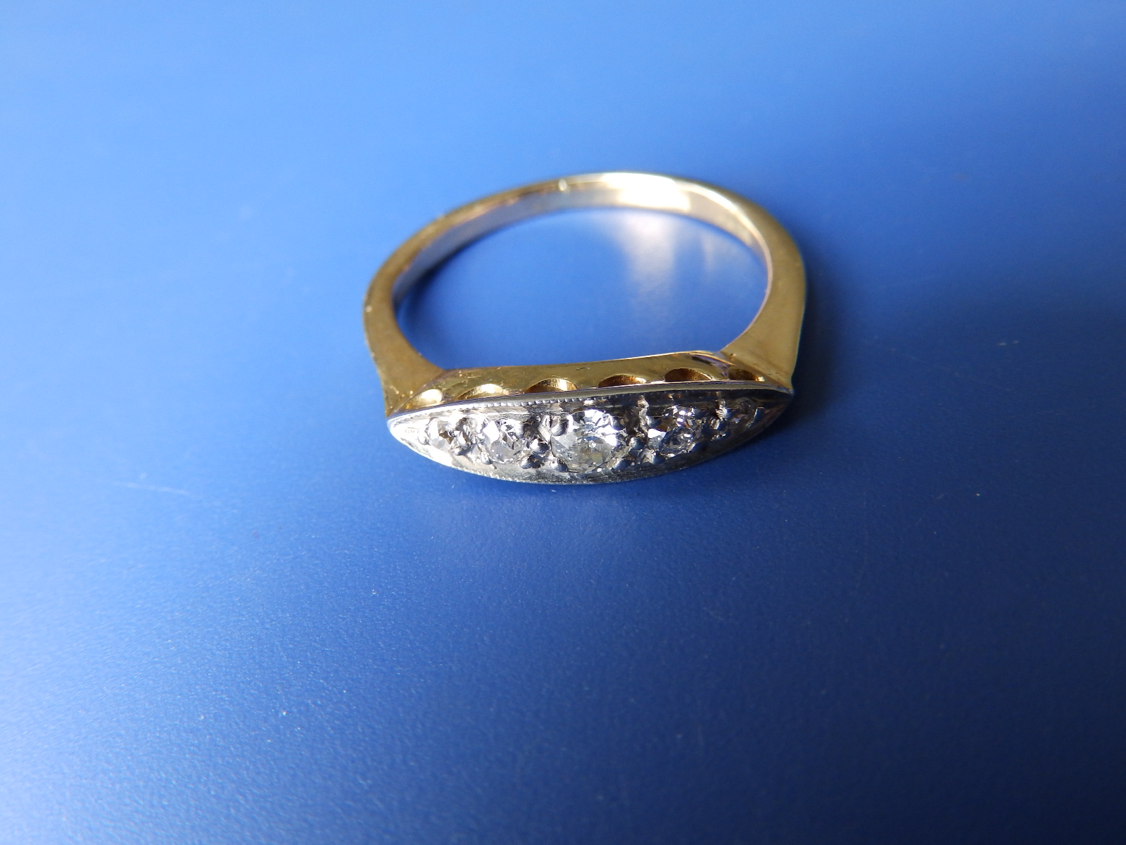 A graduated old cut five stone diamond ring on yellow metal shank with 'PLAT' setting, total diamond