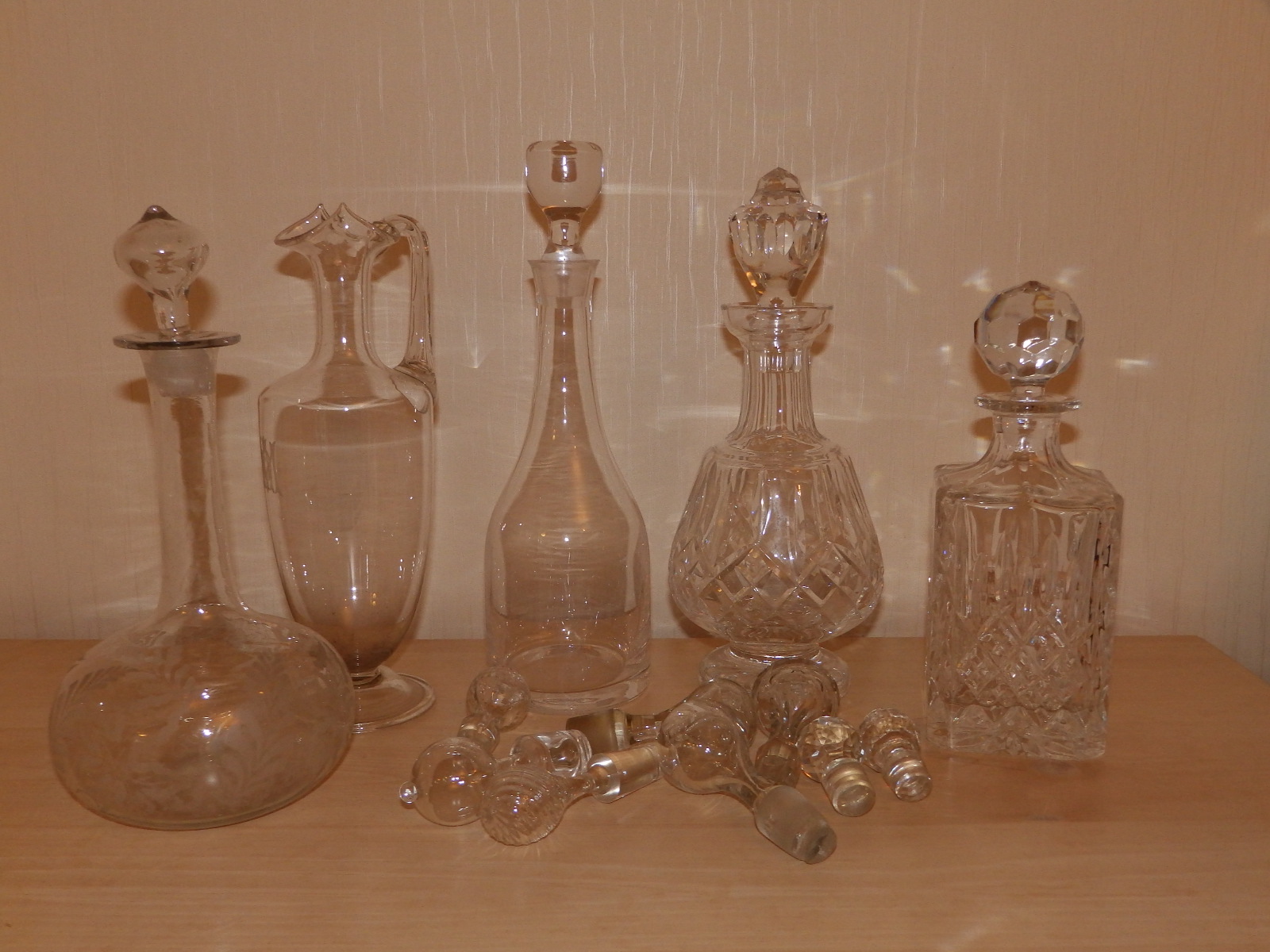 Four various decanter, a ewer and six stoppers.