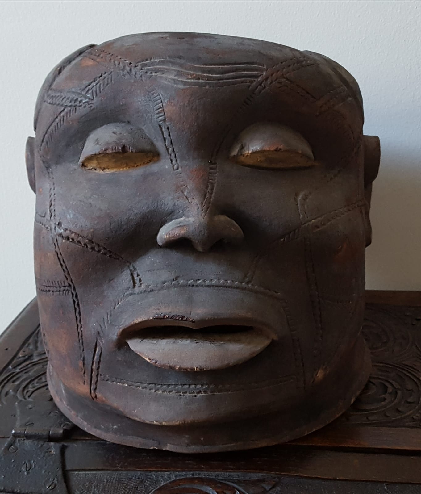 An African Makonde helmet mask, the face with extensive scarification.