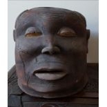 An African Makonde helmet mask, the face with extensive scarification.