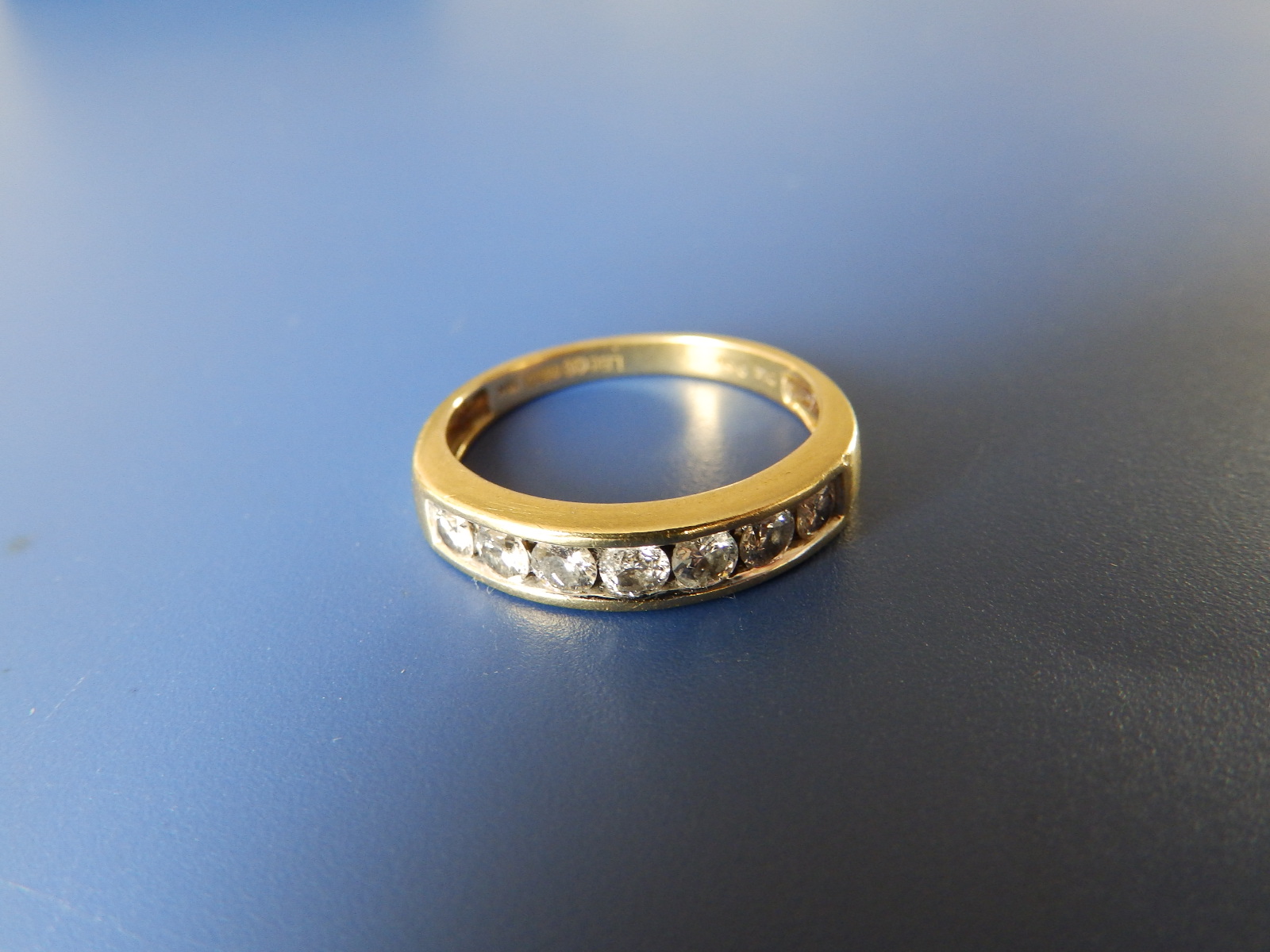 A diamond set 18ct gold half eternity ring - total diamond weight 0.50 carat. Finger size M.