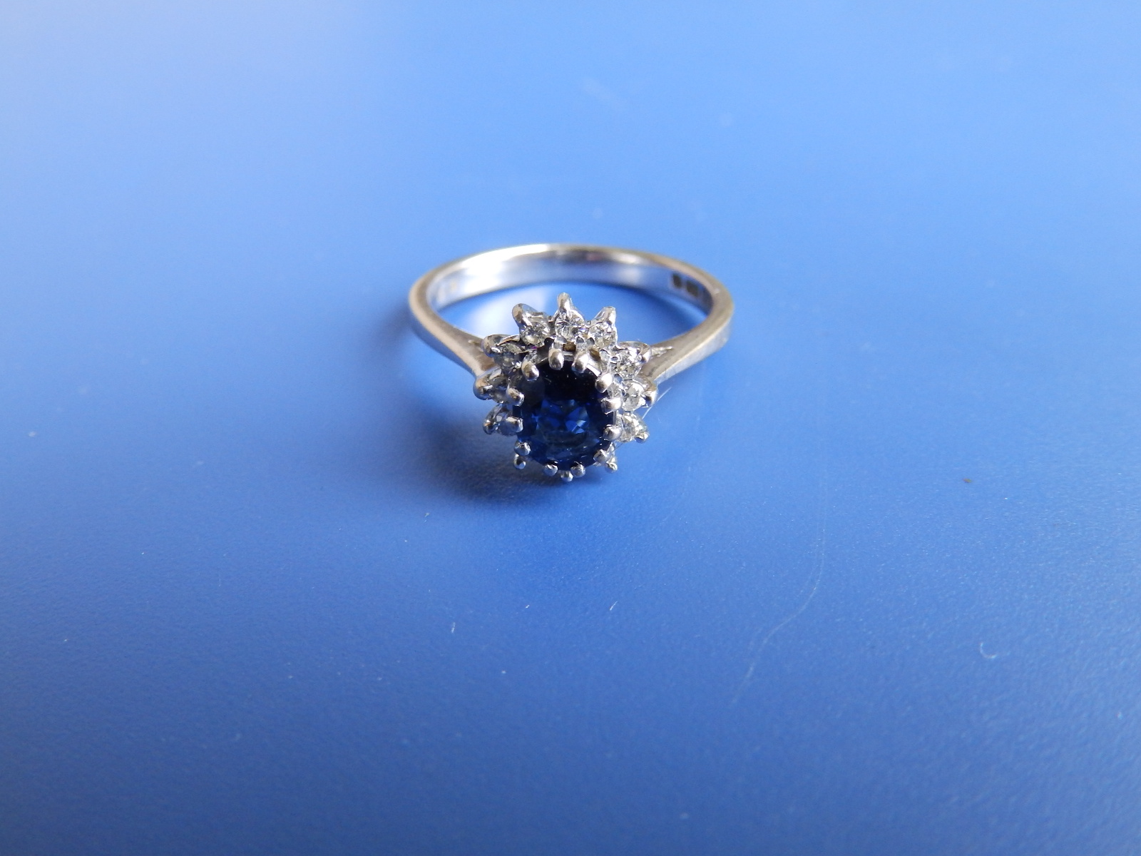 A small modern oval sapphire & diamond cluster ring in 18ct white gold. Finger size K/L.