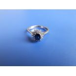 A small modern oval sapphire & diamond cluster ring in 18ct white gold. Finger size K/L.