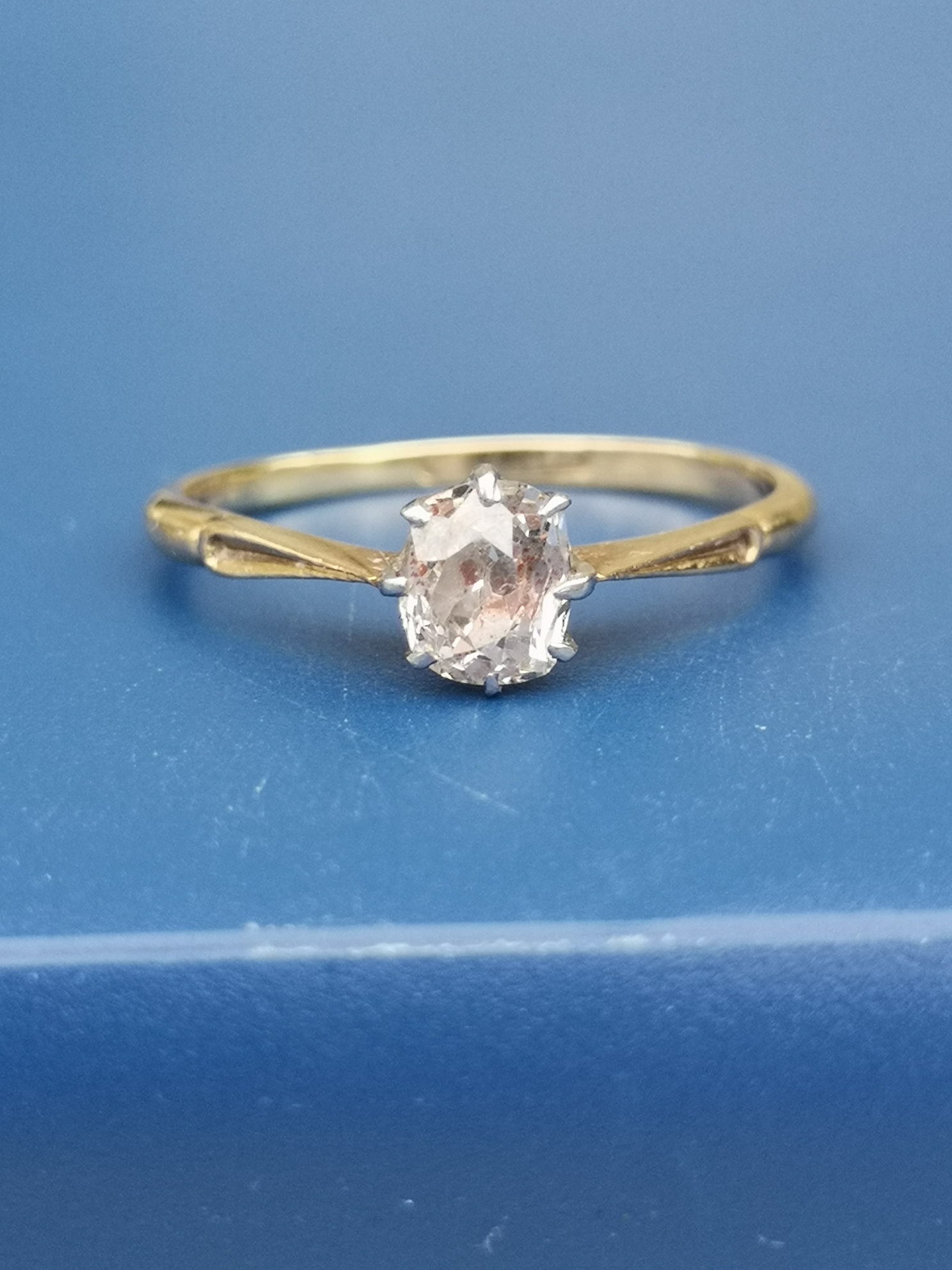 An old cushion cut diamond solitaire ring, the claw set stone weighing approximately 0.60 carat,