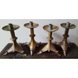 A set of four Gothic Revival heavy brass candlesticks on angular triform bases, 9.5" high.