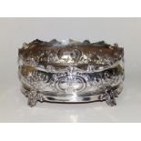 A Victorian oval crested silver bottle coaster, the scrolled rim above floral embossed sides, an