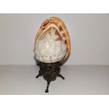 A cameo carved shell table lamp on tripod metal support, 8.75" high.