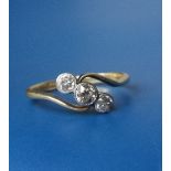 An old cut three stone diamond crossover set ring in 18ct gold & platinum. Finger size R.