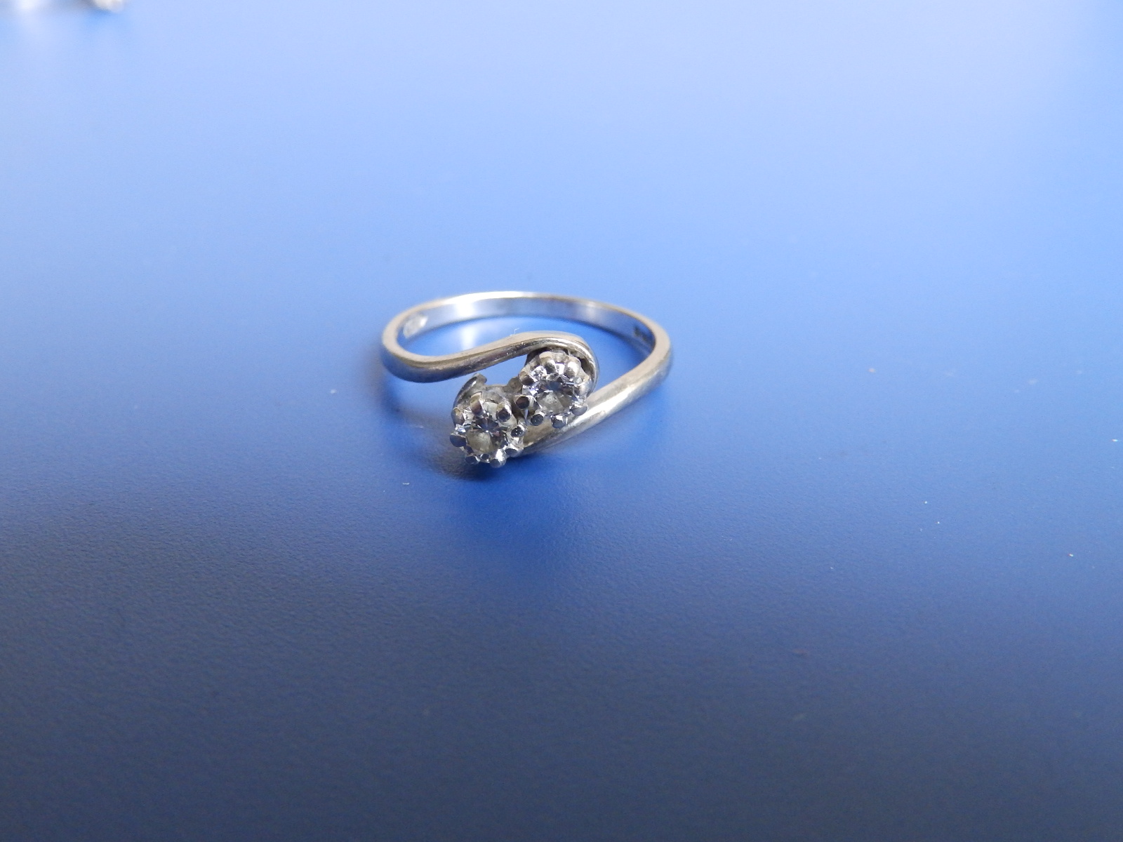 A small two stone diamond crossover set 18ct white gold ring. Finger size L.