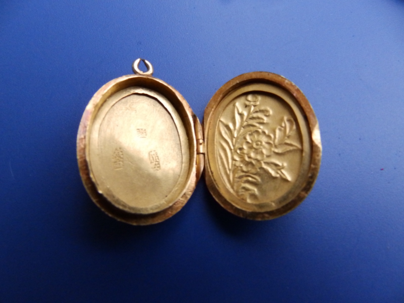 A small Chinese oval gold locket, 1.1" excluding loop - tests as 22ct, together with two small