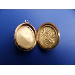 A small Chinese oval gold locket, 1.1" excluding loop - tests as 22ct, together with two small