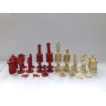 An incomplete large 19thC Indian red & white stained bone chess set, the kings 5" high - missing