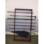 A wooden wall rack with three silver handled walking sticks and four others (8) - a/f.