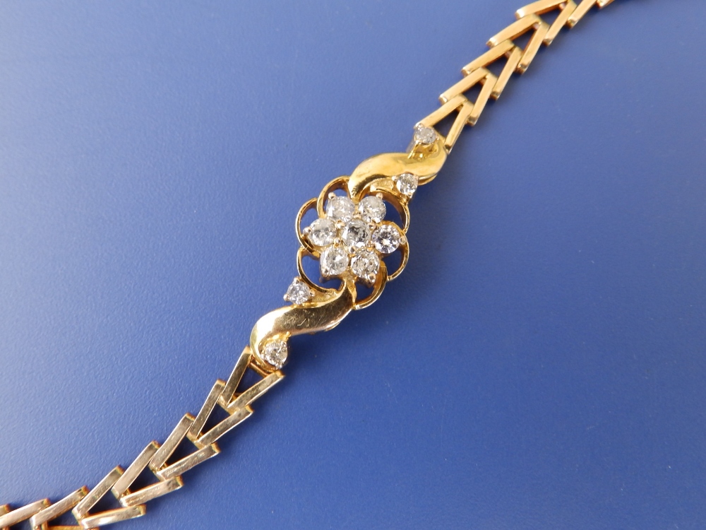 A yellow metal bracelet set with a diamond daisy cluster - tests as 18ct, 6.6"