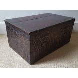 An antique carved wooden box, decorated to all sides, with plain hinged lid, Width 23.5".