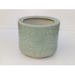 A small antique Chinese celadon glazed jardiniere, of cylindrical form, having incised decoration of
