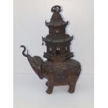 A 19thC Chinese bronze elephant carrying an elaborate two tier howdah of pagoda form, in