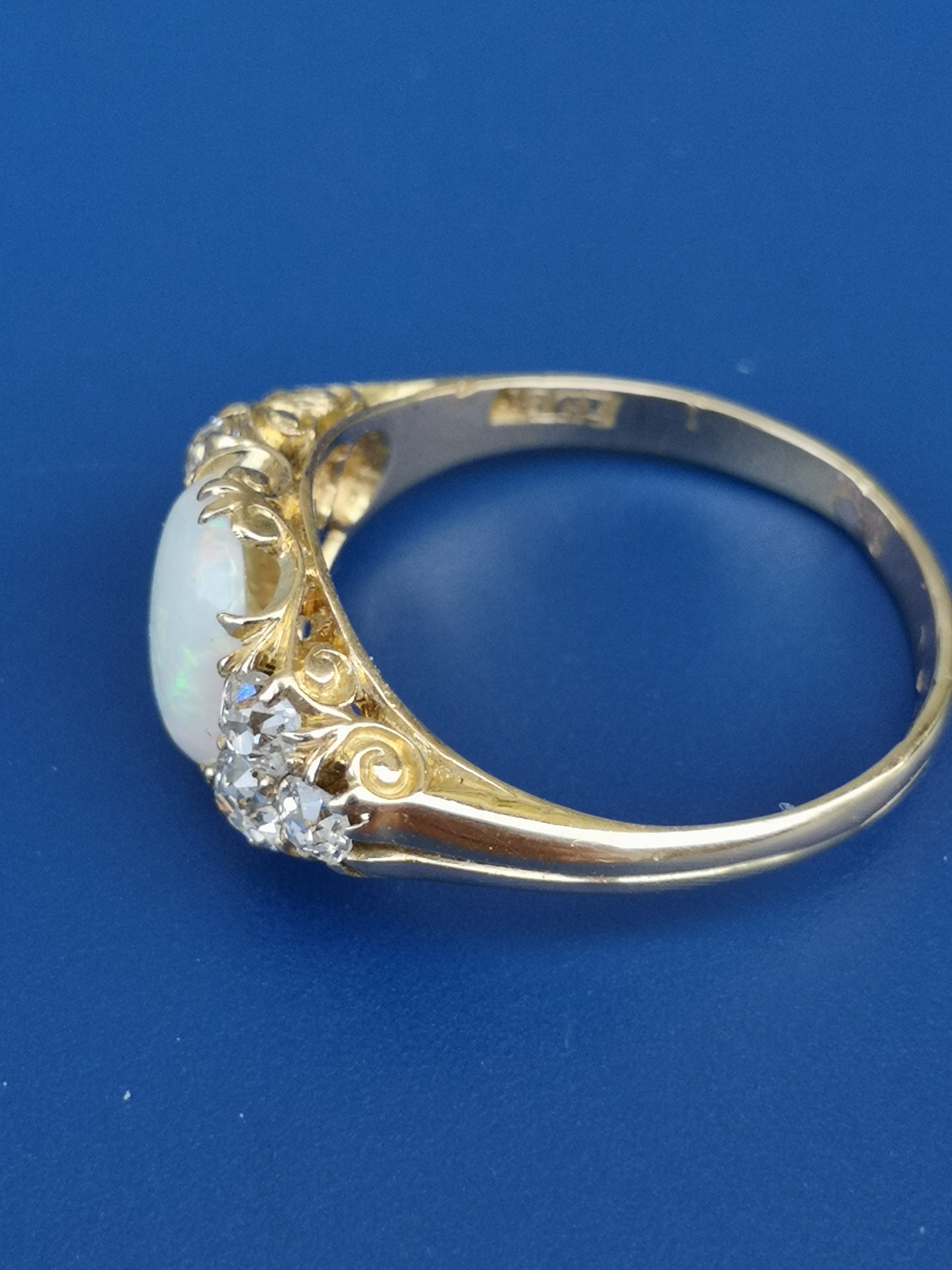 An opal & diamond set 18ct gold ring, the oval claw set opal flanked by six old cut diamonds. Finger - Image 2 of 3