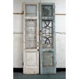 Two part stripped pine panelled doors, with wrought iron decorative centres height +/- 278 cm,