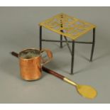 A Victorian brass and iron trivet, a mahogany handled long spoon and a copper measure.