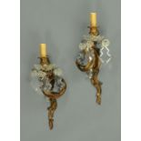 A pair of French gilt bronze wall lustres, with faceted glass drops, circa 1900. Height 38 cm.