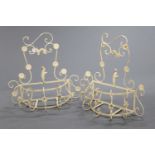 A pair of wrought iron garden planters, in a cream colour with floral decoration.