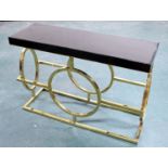 A modern hall table, with black glass top and brass effect base.