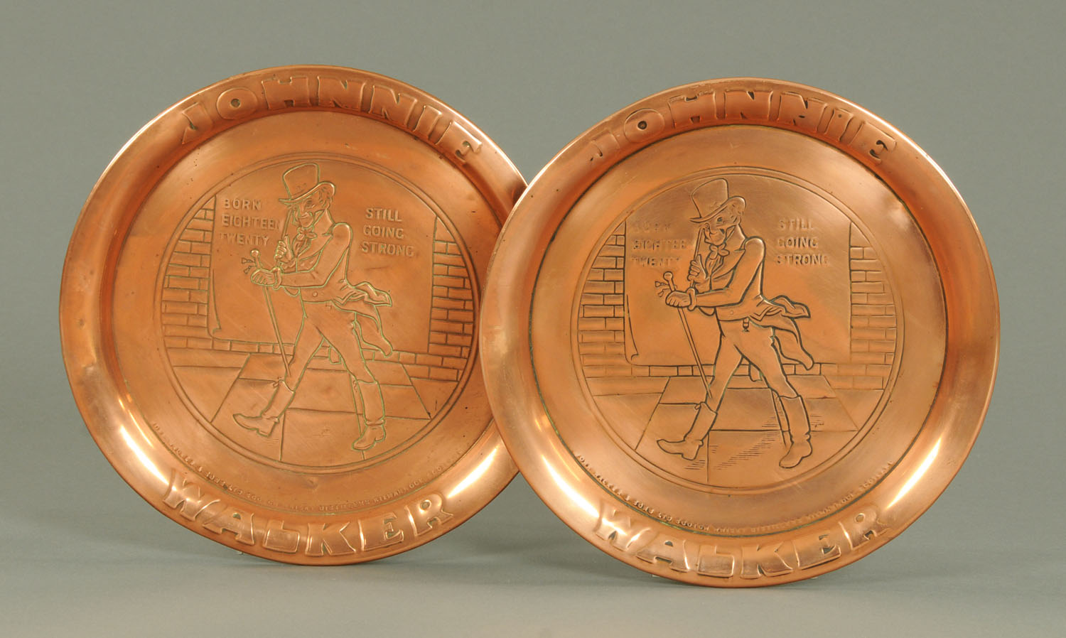 A pair of Johnnie Walker copper pub trays. Diameter 33 cm.