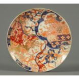 A Japanese Imari plate, late 19th century, decorated in typical Imari colours with gilding.