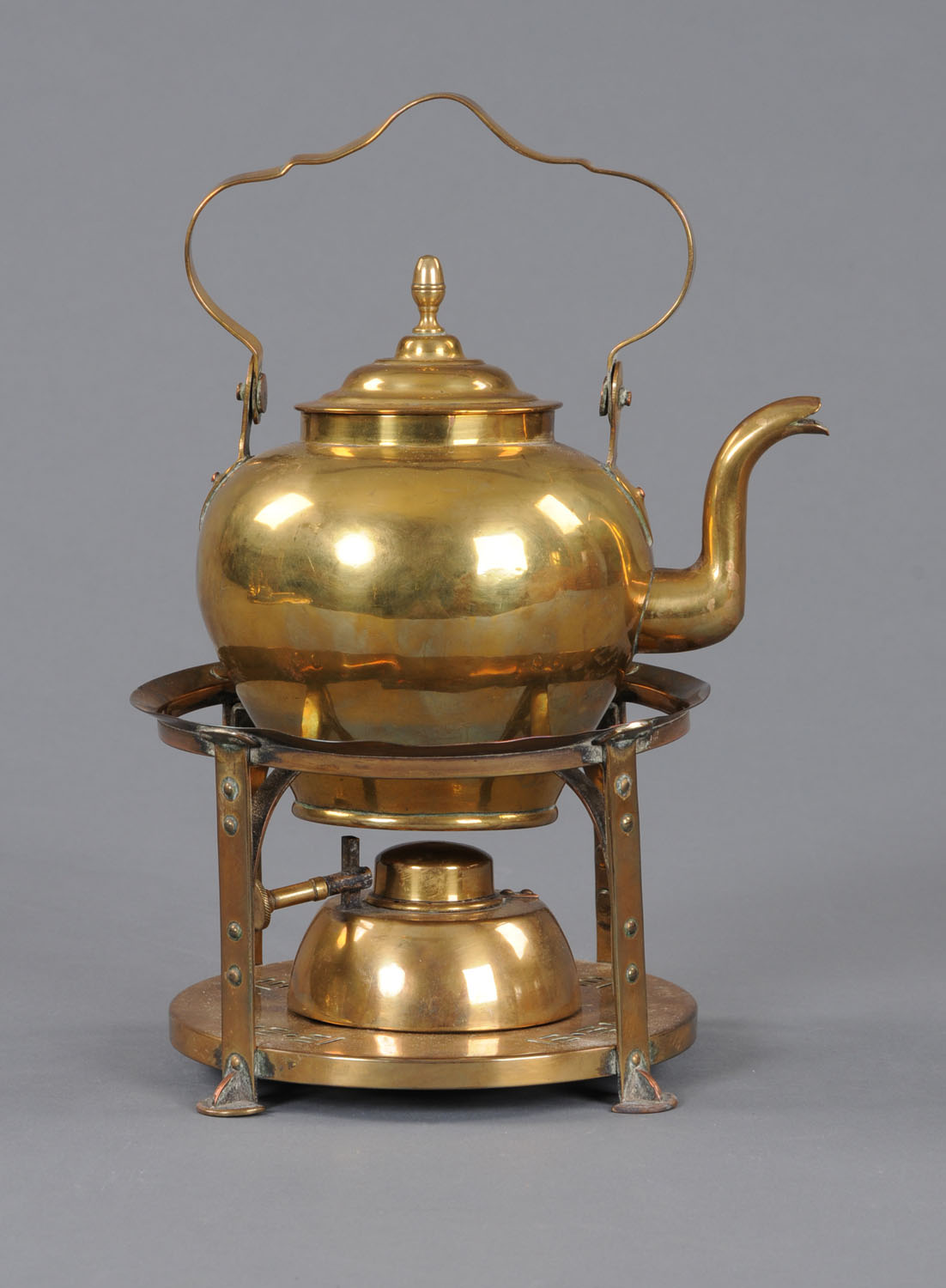 A late 19th century brass kettle, with stand and burner, in the Arts and Crafts style.