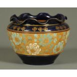 A Royal Doulton jardiniere, with blue ground and relief moulded gilt and foliate decorated band.