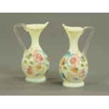 A pair of Victorian opaque glass vases, with folded rims and hand painted with floral sprays.