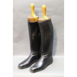 A pair hunting boots with wooden shoe trees, black approximate size 8.