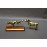 A brass car mascot in the form of a running fox, mounted on a mahogany plinth.