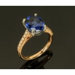 An 18 ct gold synthetic sapphire ring, with diamond set shoulders, sapphire 4.