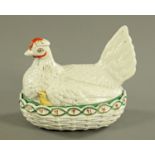 A 19th century Staffordshire hen on nest egg cruet, chick showing, principally white with red comb.