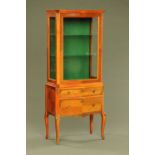 A Continental style serpentine fronted glazed cabinet on stand,