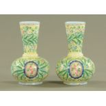 A pair of Victorian glass club shaped vases, each handpainted with foliate scrolling designs.