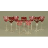 A collection of nine assorted cranberry glass overlay wine glasses.