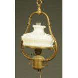 A late 19th century brass oil lamp, hanging, with opaque glass shade. Height +/- 64 cm.