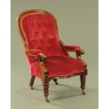A Victorian mahogany framed gentleman's armchair, with deep buttoned back and padded arms,