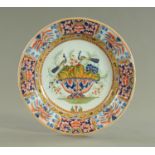 An 18th century Delft ware plate, decorated with a bowl of fruit and peacocks. Diameter 35 cm.